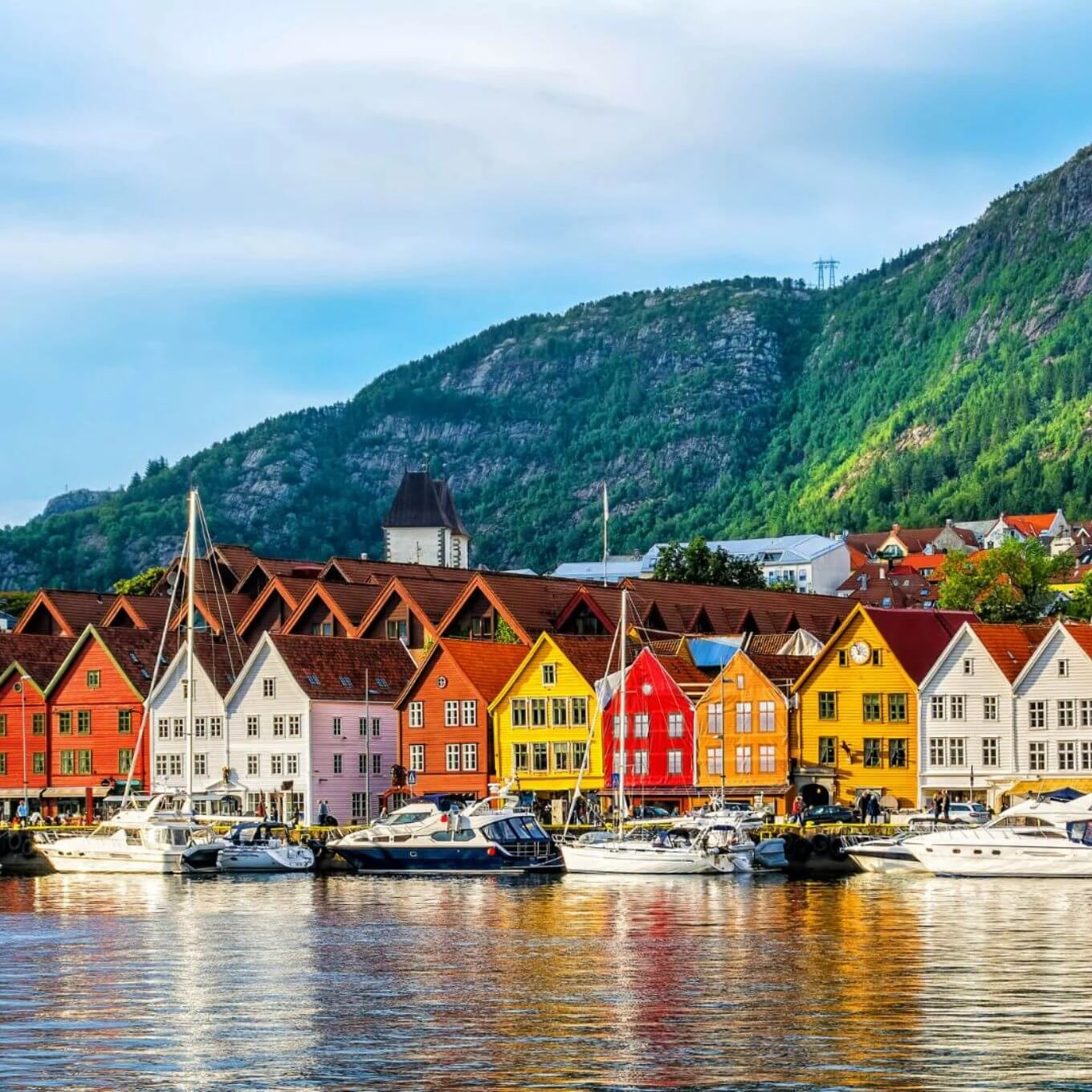 Casas de colores se reflejan en el agua, creando una pintoresca escena en Borlenga, Noruega.