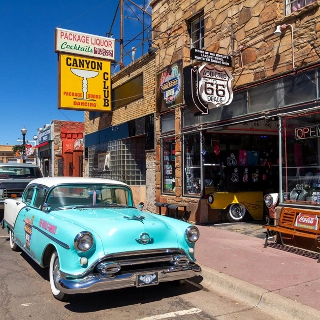 Un coche clásico estacionado frente a una tienda, destacando su diseño vintage y la arquitectura del local.