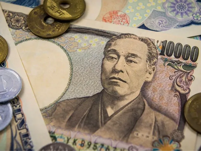 Un surtido de moneda japonesa, incluidas monedas y billetes, expuestos juntos sobre una superficie plana.