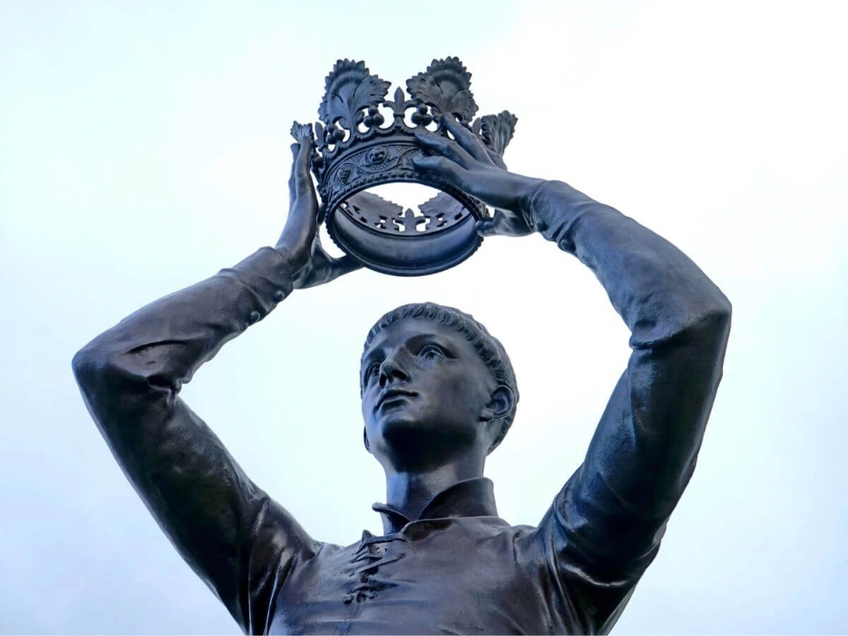 Una estatua de un hombre que lleva con orgullo una corona, símbolo de autoridad y liderazgo.