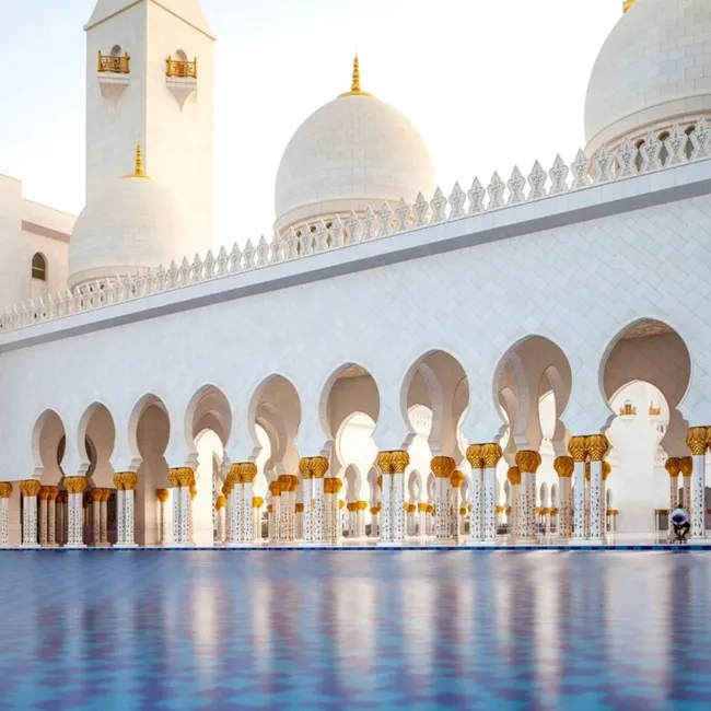 Una impresionante vista de la Gran Mezquita Sheikh Zayed de Abu Dhabi, con sus majestuosas cúpulas y sus complejos detalles arquitectónicos.